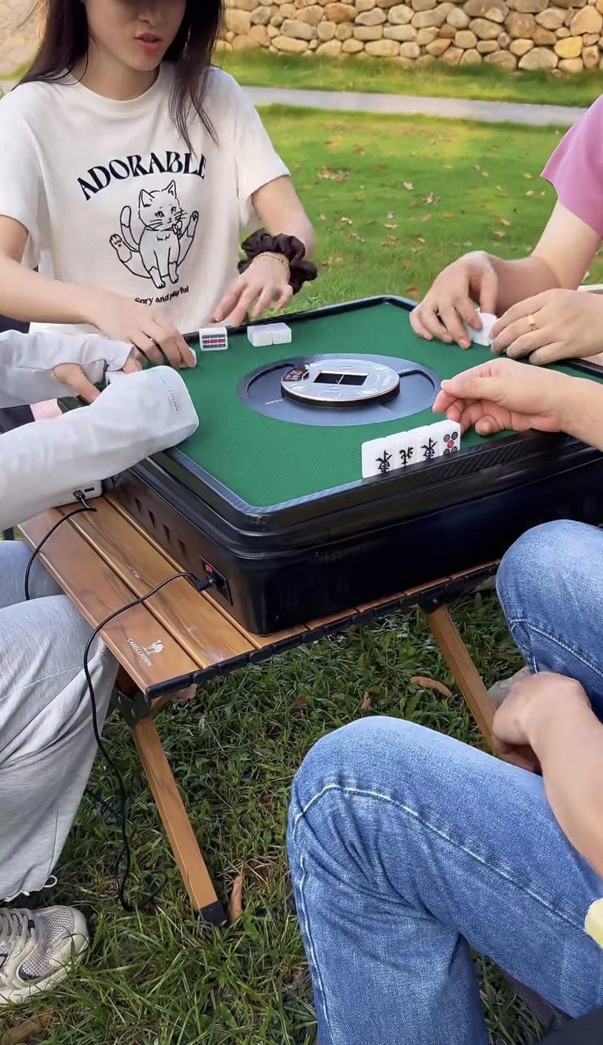Empat orang main mahjong di luar ruangan